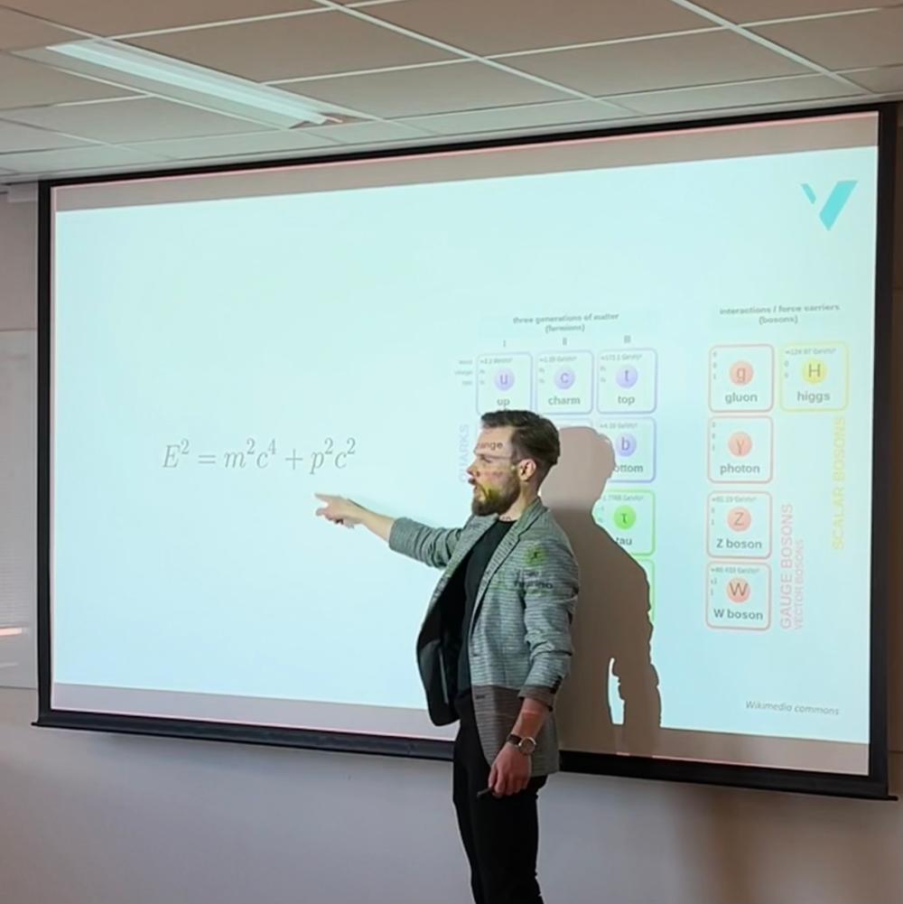 Steffen Mæland at the AI seminar. He is pointing to an equation on one of his slides. It reads E2=m2c4+p2c2