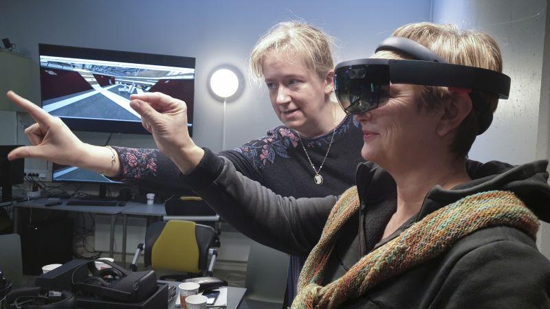 Person using VR headset with help from an instructor at VR lab. Photo