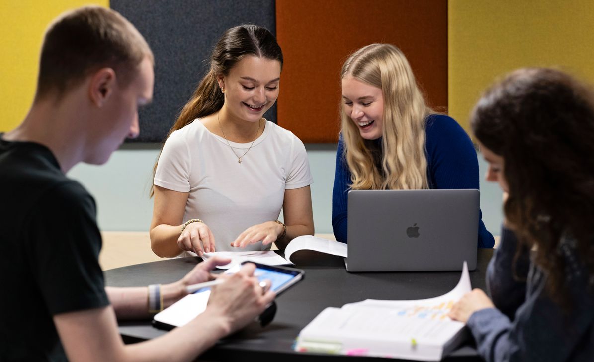 Four students around a table in a group room