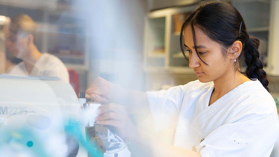 A female student working with a machine in a laboratory