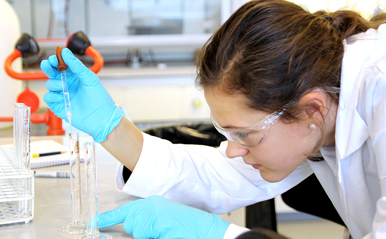 A woman measuring liquids in a tube