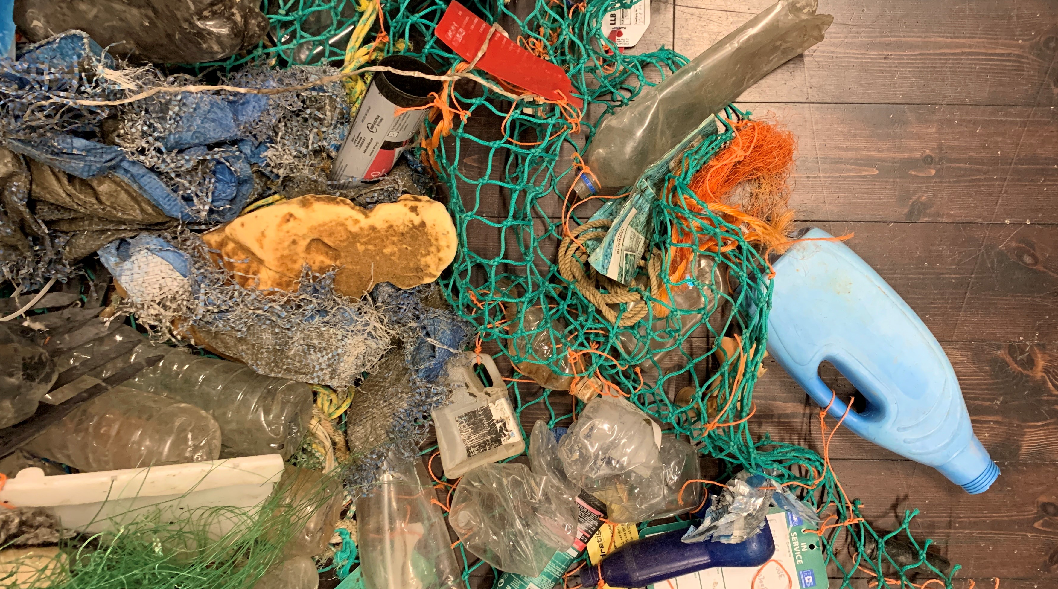 Image of plastic waste of different kind caught in a fishing net. 