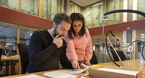 Two students study a historical document.