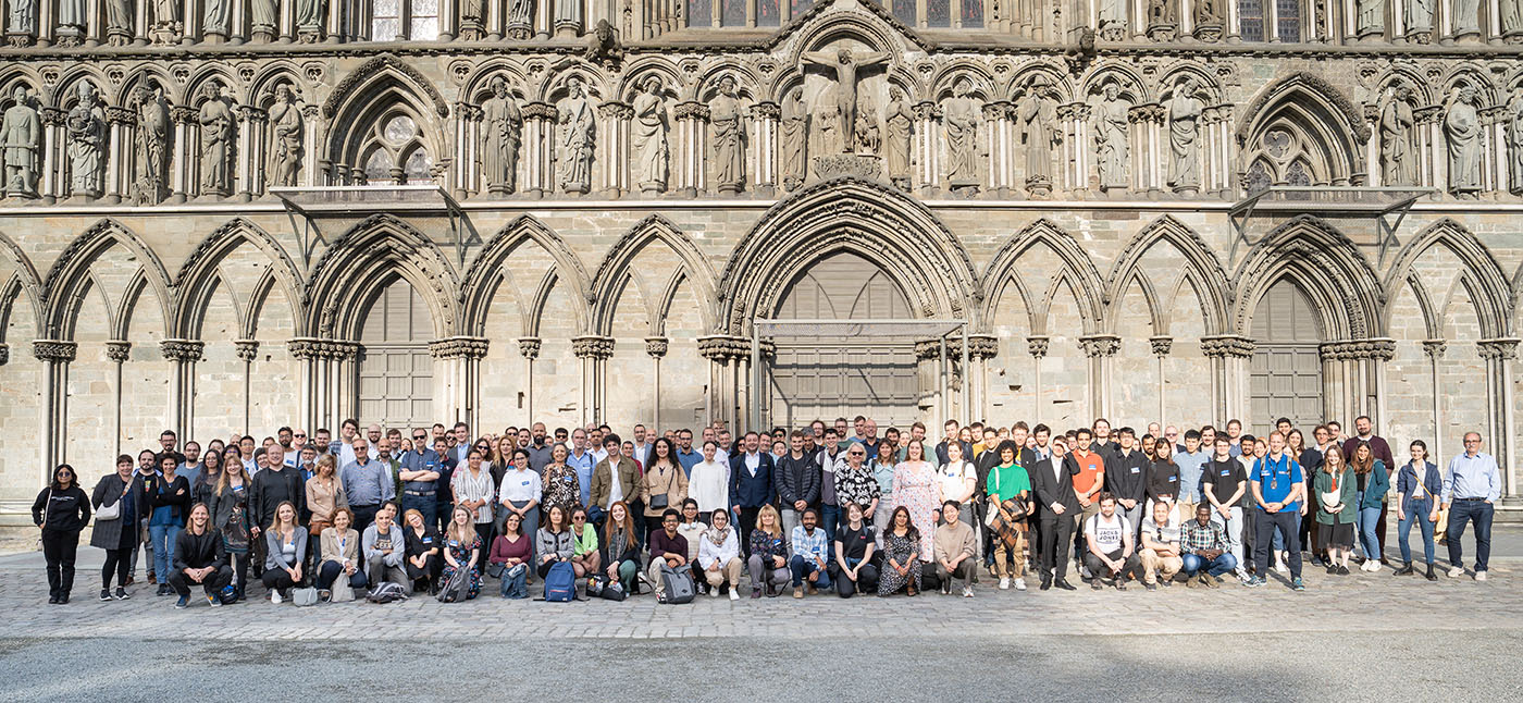 Group photo of attendees to ECAPD 2025 in front of the ornate west wall of Nidaros Cathedral