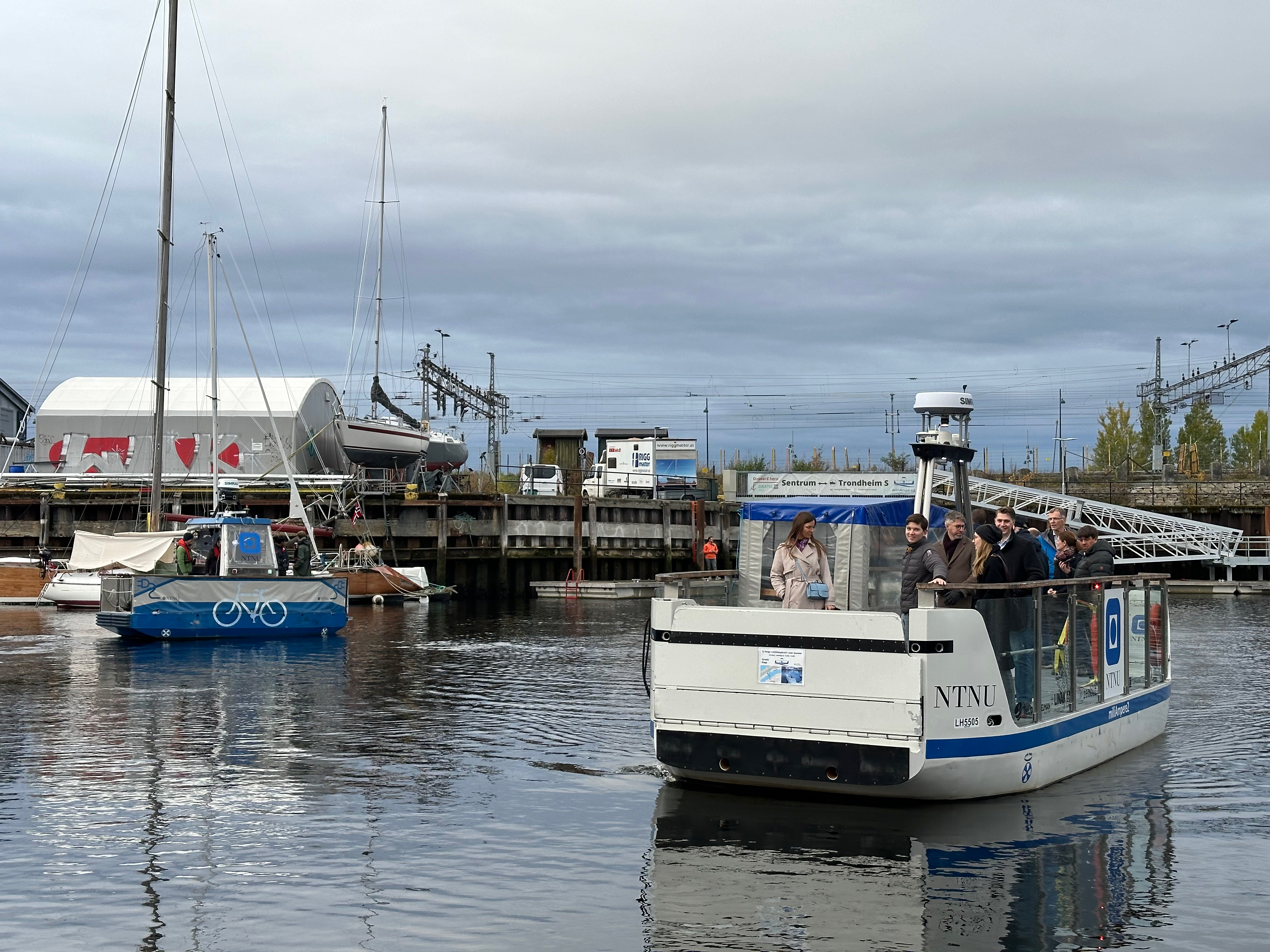 NTNU's autonomous ferries crossing the canal by Ravnkloa in Trondheim. MilliAmpere 2 in the foreground and milliampere 1 in the background.