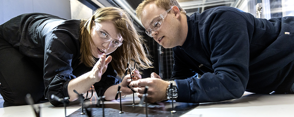 Man and woman with goggles looking at windmills in mini version. Photo: Geir Mogen/NTNU