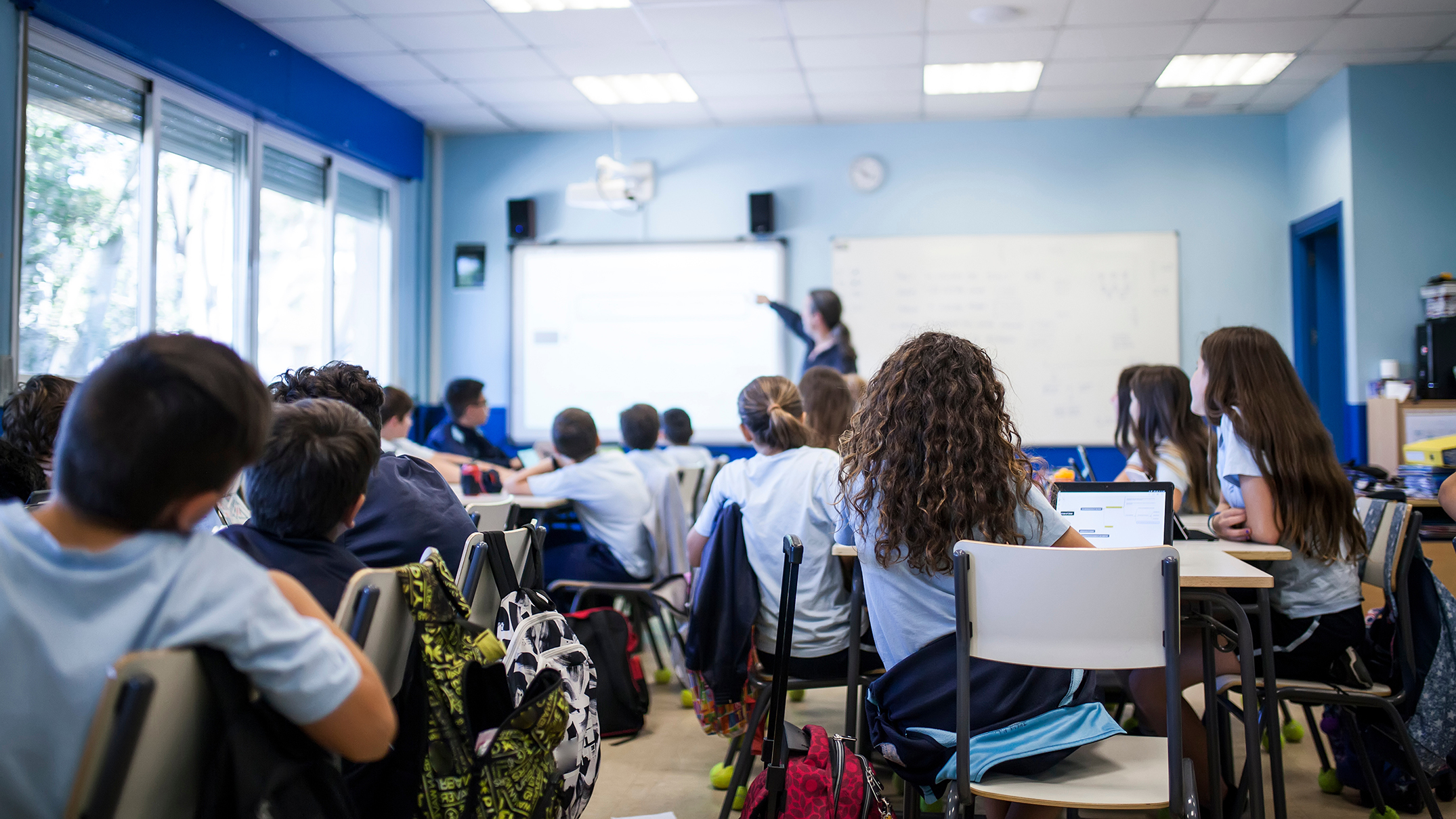 Photo of students in a classroom with a teacher in front.