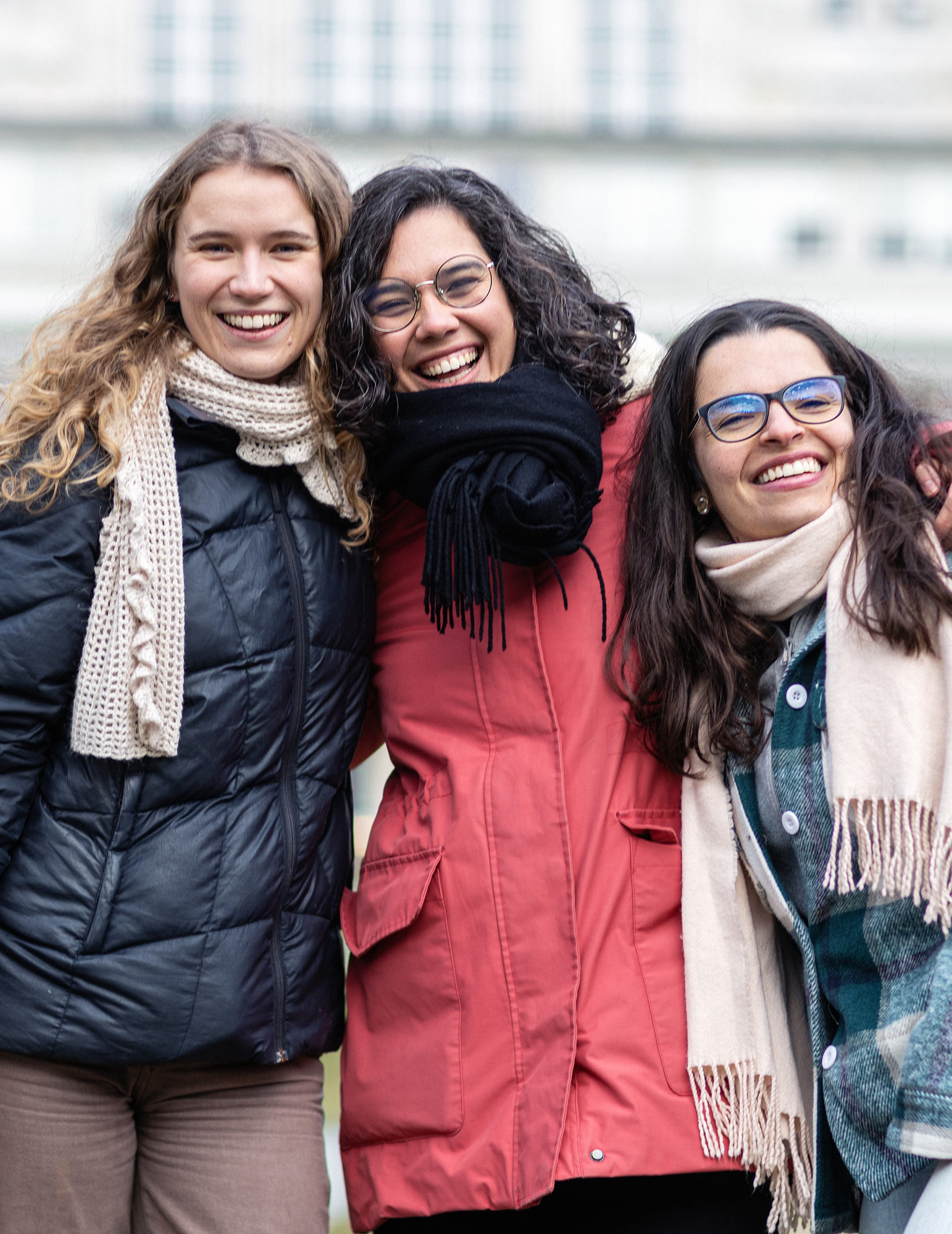 Three smiling students, on campus. Photo.