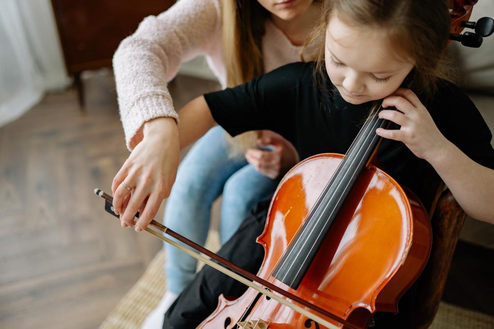 A Child learns to play the cello. Photo