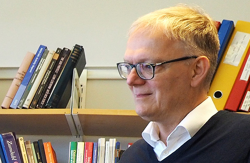 A man with books in the background