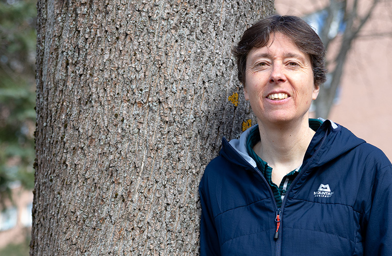 A woman leaning on a big tree